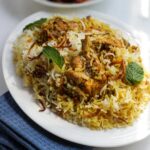 Close-up of flavorful chicken biryani garnished with mint leaves, perfect for a savory meal.