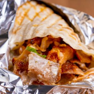Tasty chicken shawarma wrapped in flatbread and foil, ready to enjoy.