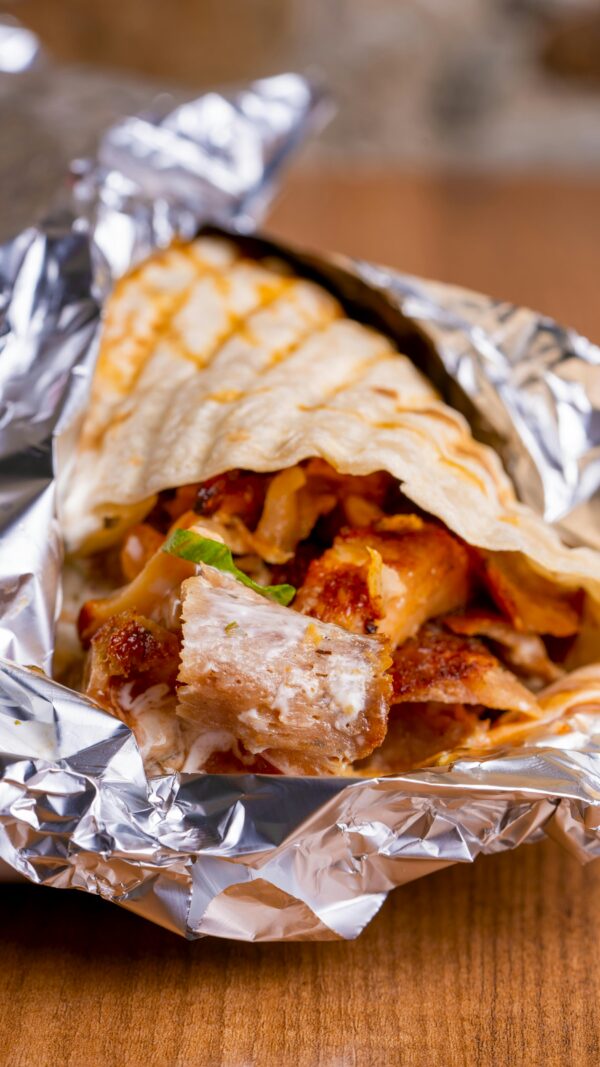 Tasty chicken shawarma wrapped in flatbread and foil, ready to enjoy.