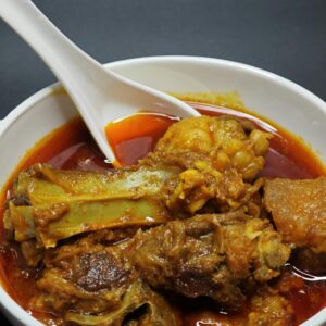 Delicious Indian mutton curry served in a white bowl, rich with spices.
