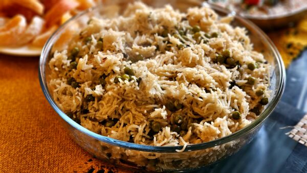 Mouthwatering pea pulao served hot in a transparent glass bowl, perfect for any meal.