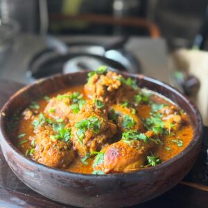 Savor the rich flavors of homemade Indian chicken curry garnished with cilantro. Perfect for food lovers.