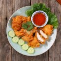 pexels-photo-34834582-34834582 Delicious crispy fried chicken served with lettuce, cucumber, and sweet chili sauce.